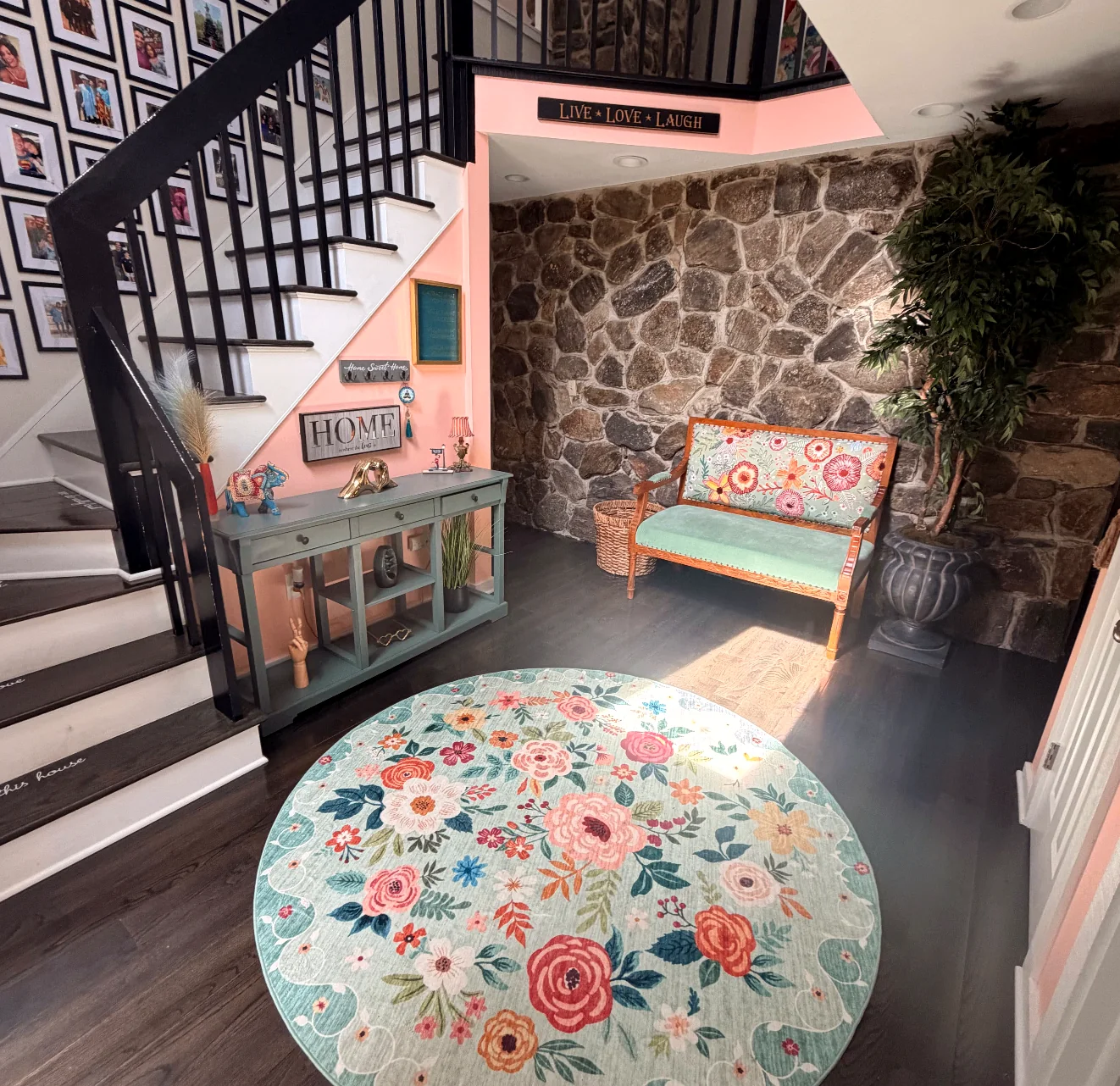 Entry hall with a stone wall, staircase, and floral rug