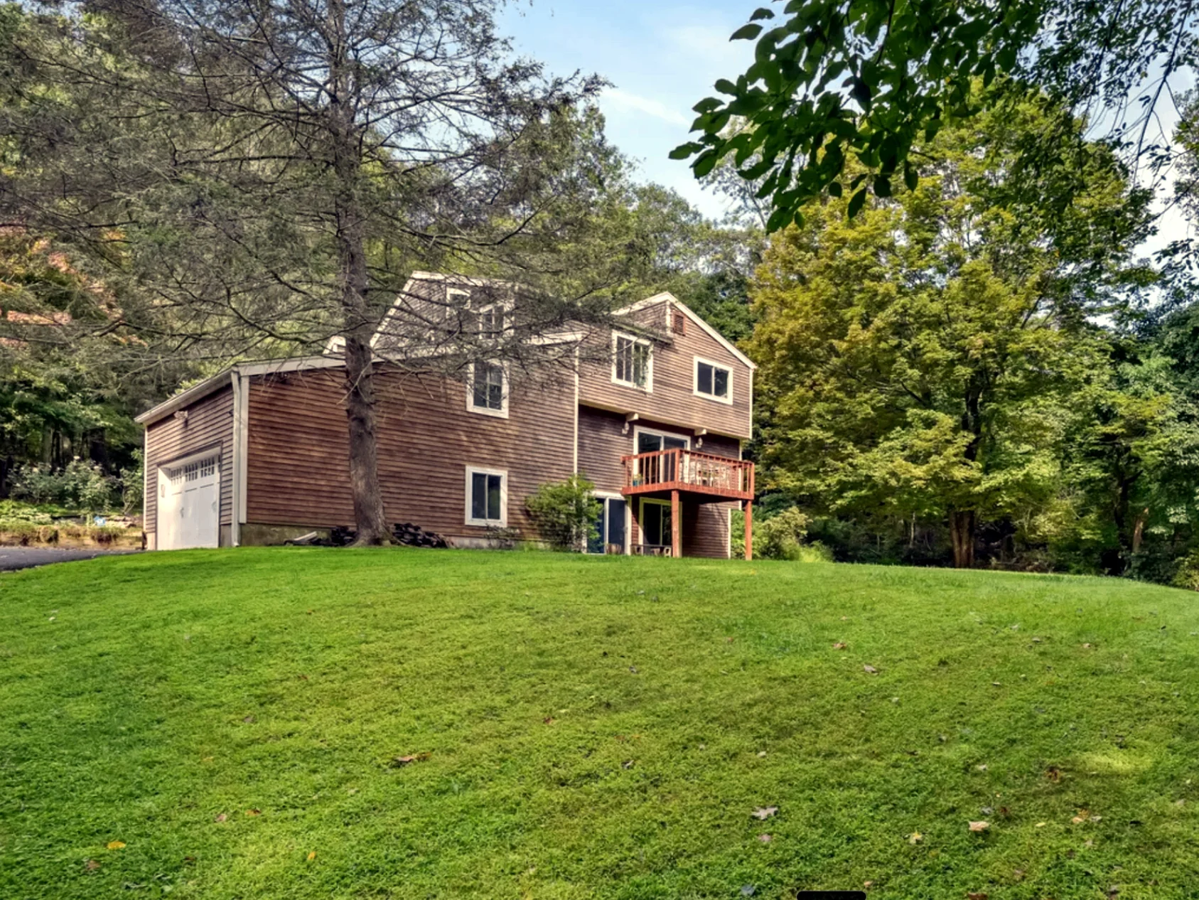 Exterior view of the cedar-sided house from across the lawn